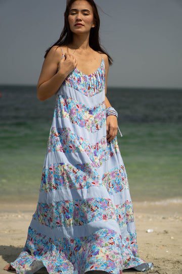 Flowy summer beach dress made of natural viscose fabric. The design includes 11 alternating panels of six blue floral fabric sections and five light blue fabric sections in a downward arrow pattern. The dress touches the ground and has pockets!