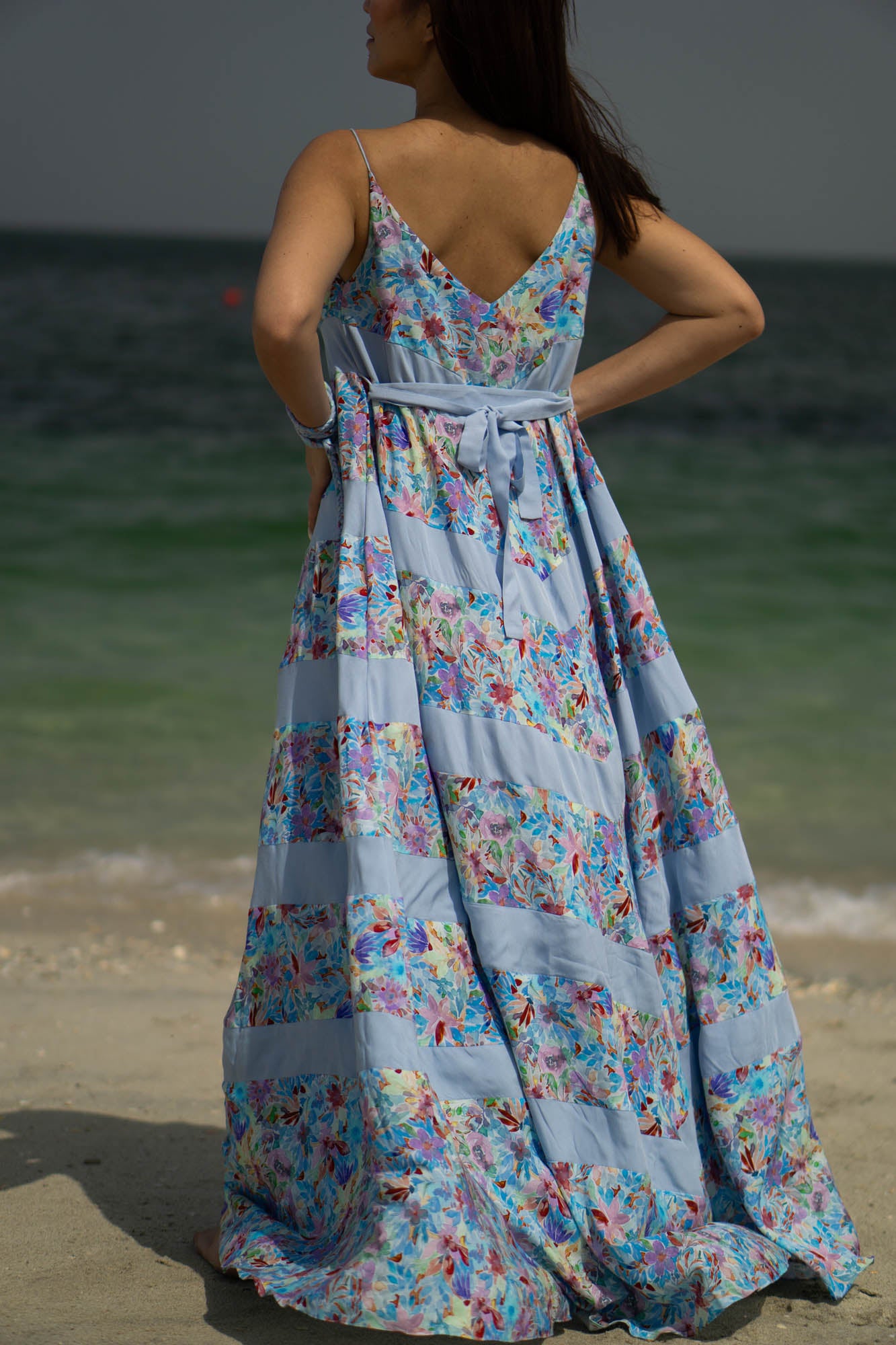 The back of the dress is a deep v line with belt hoops and a strap of blue solid color fabric to adjust at the waist.