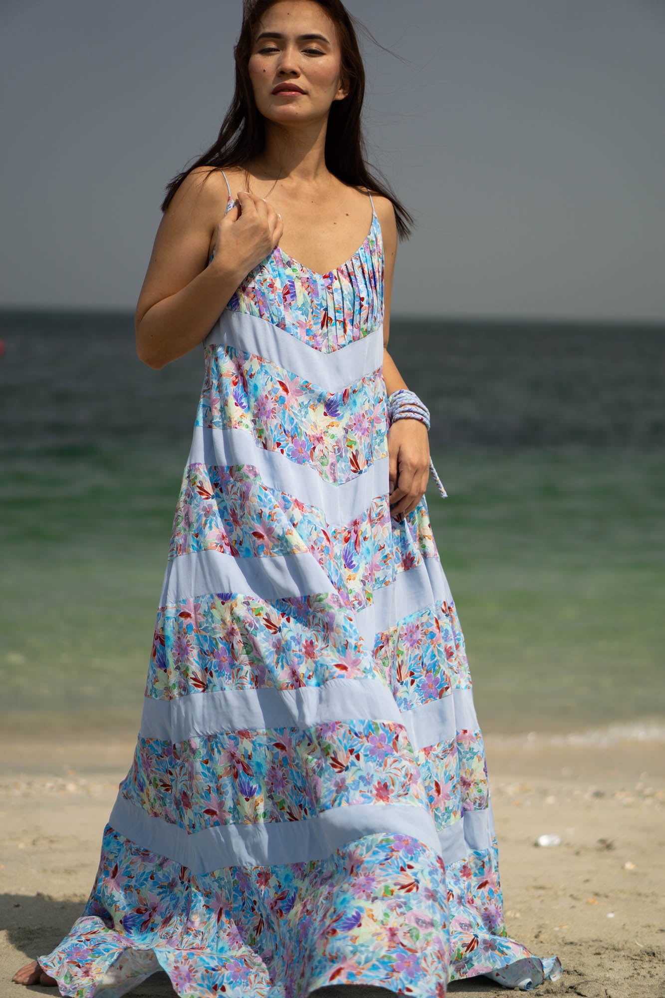 Flowy summer beach dress made of natural viscose fabric. The design includes 11 alternating panels of six blue floral fabric sections and five light blue fabric sections in a downward arrow pattern. The dress touches the ground and has pockets!