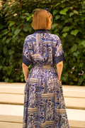 Back view of Blue bohemian printed maxi shirt dress for women with button-down front and modest silhouette, the dress shirt has a solid colour collar and sleeve cuffs. The dress also consist of pockets!