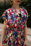 Women wearing a retro V-neck A-line maxi dress with bold printed design. The dress also consist of pockets!