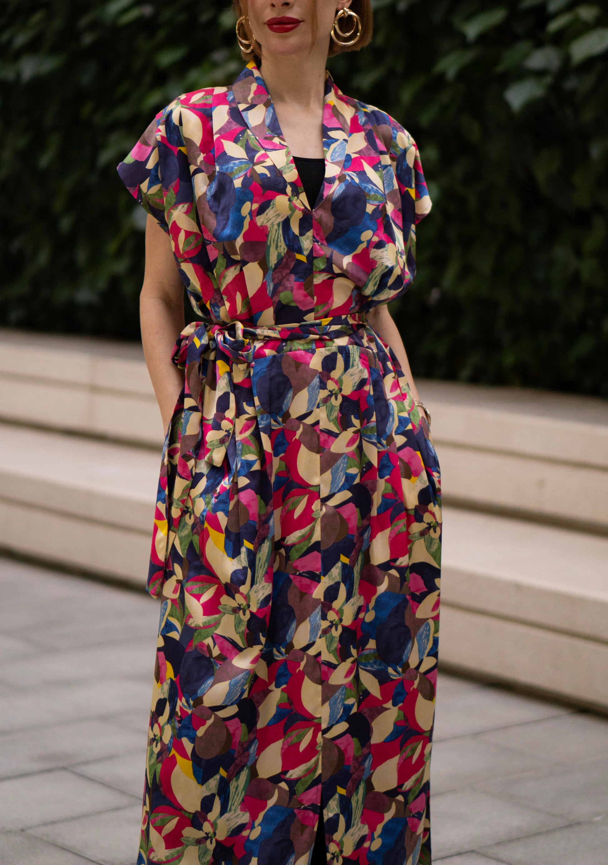 Women wearing a retro V-neck A-line maxi dress with bold printed design. The dress also consist of pockets!