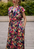 Women wearing a retro V-neck A-line maxi dress with bold printed design. The dress also consist of pockets!