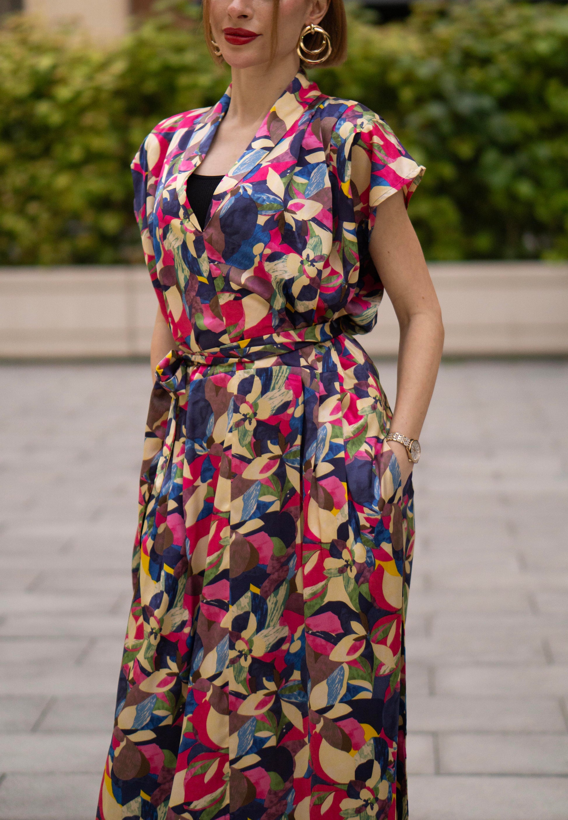 Women wearing a retro V-neck A-line maxi dress with bold printed design. The dress also consist of pockets!